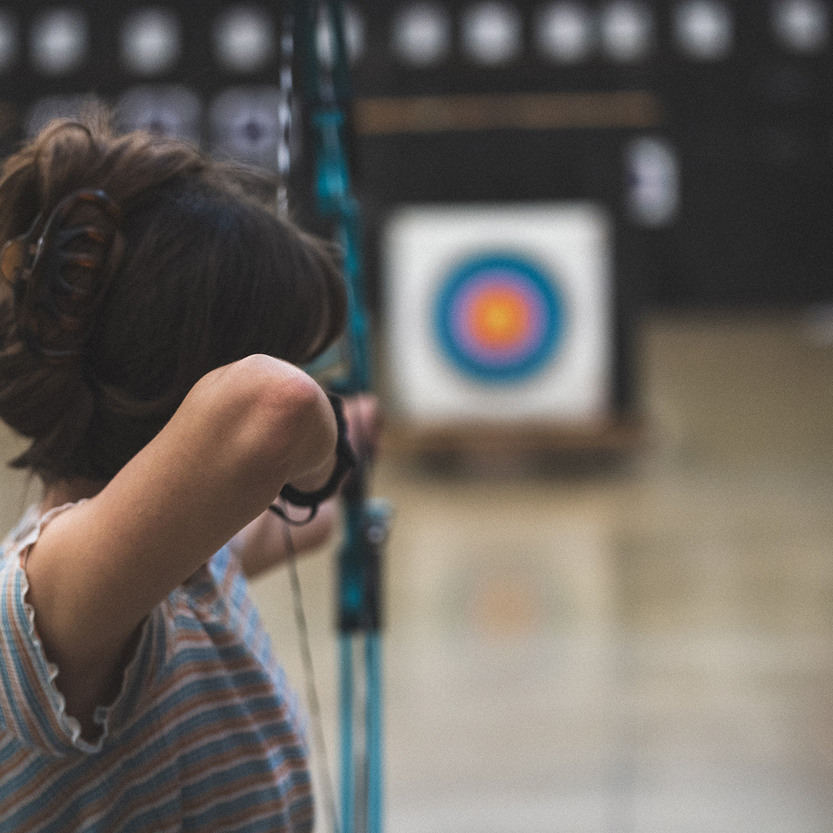Person practicing archery with targets in the background