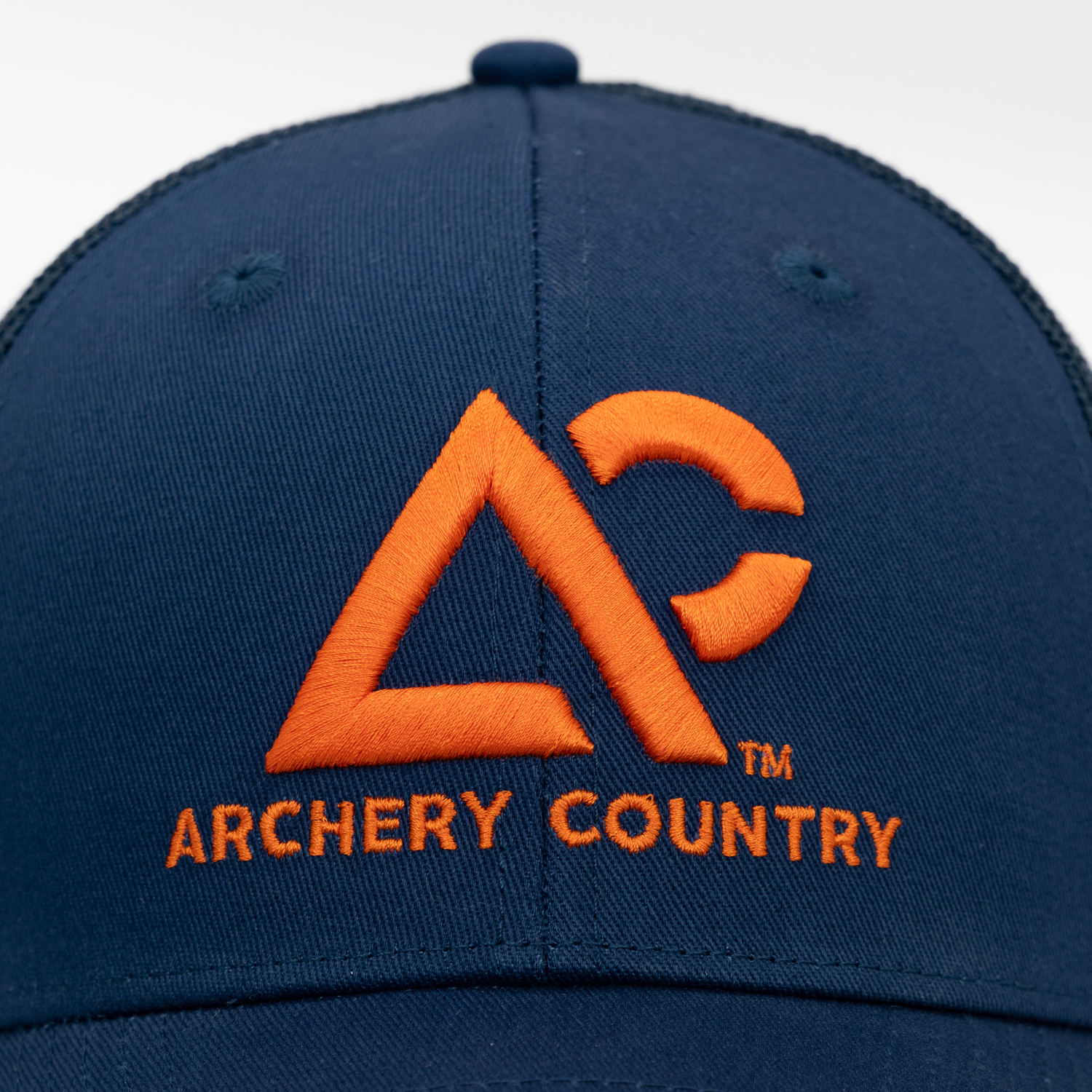 Closeup of navy meshback cap with "ARCHERY COUNTRY" logo on front in orange