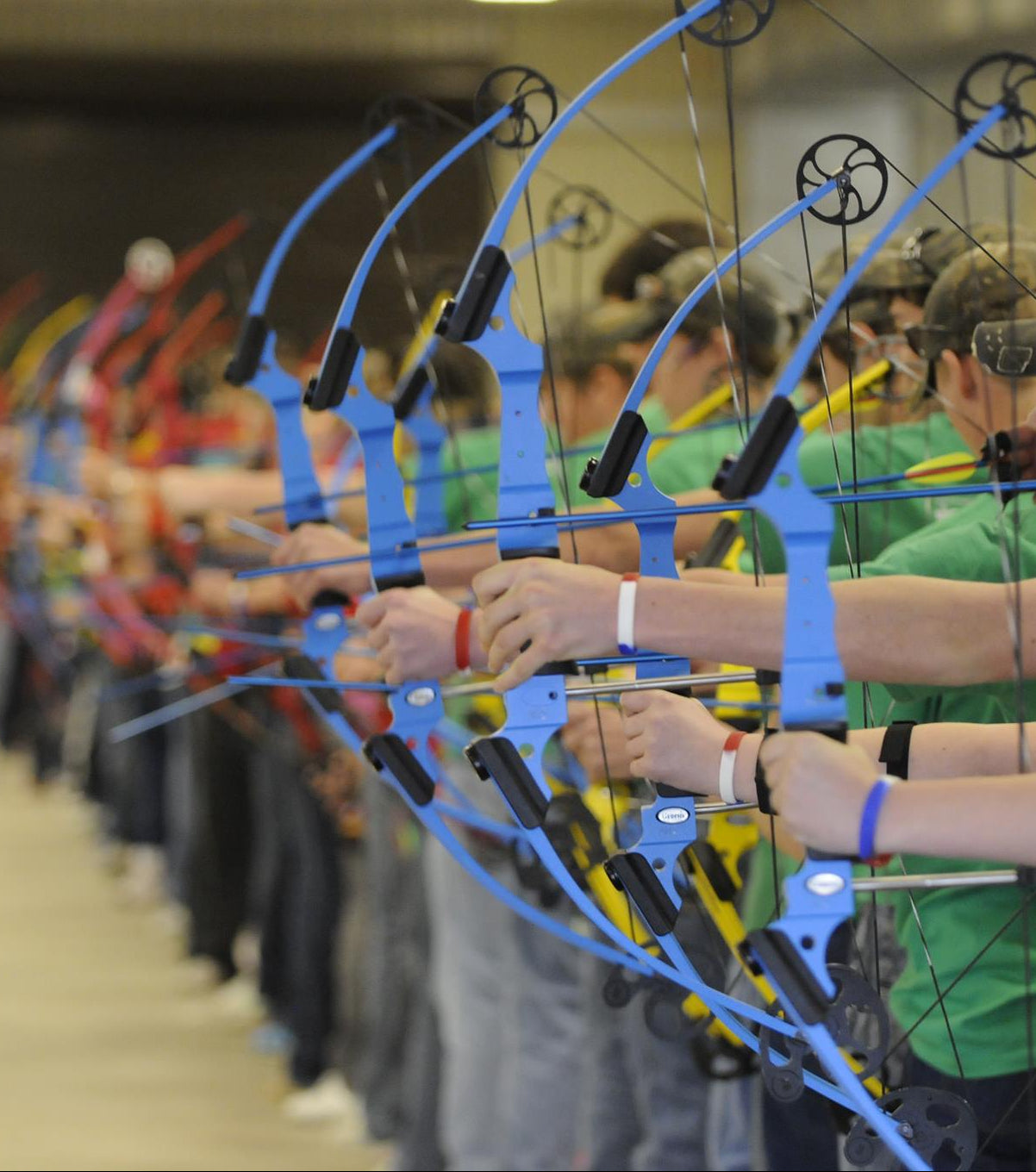 Group of people with archery bows in a line, blurred background