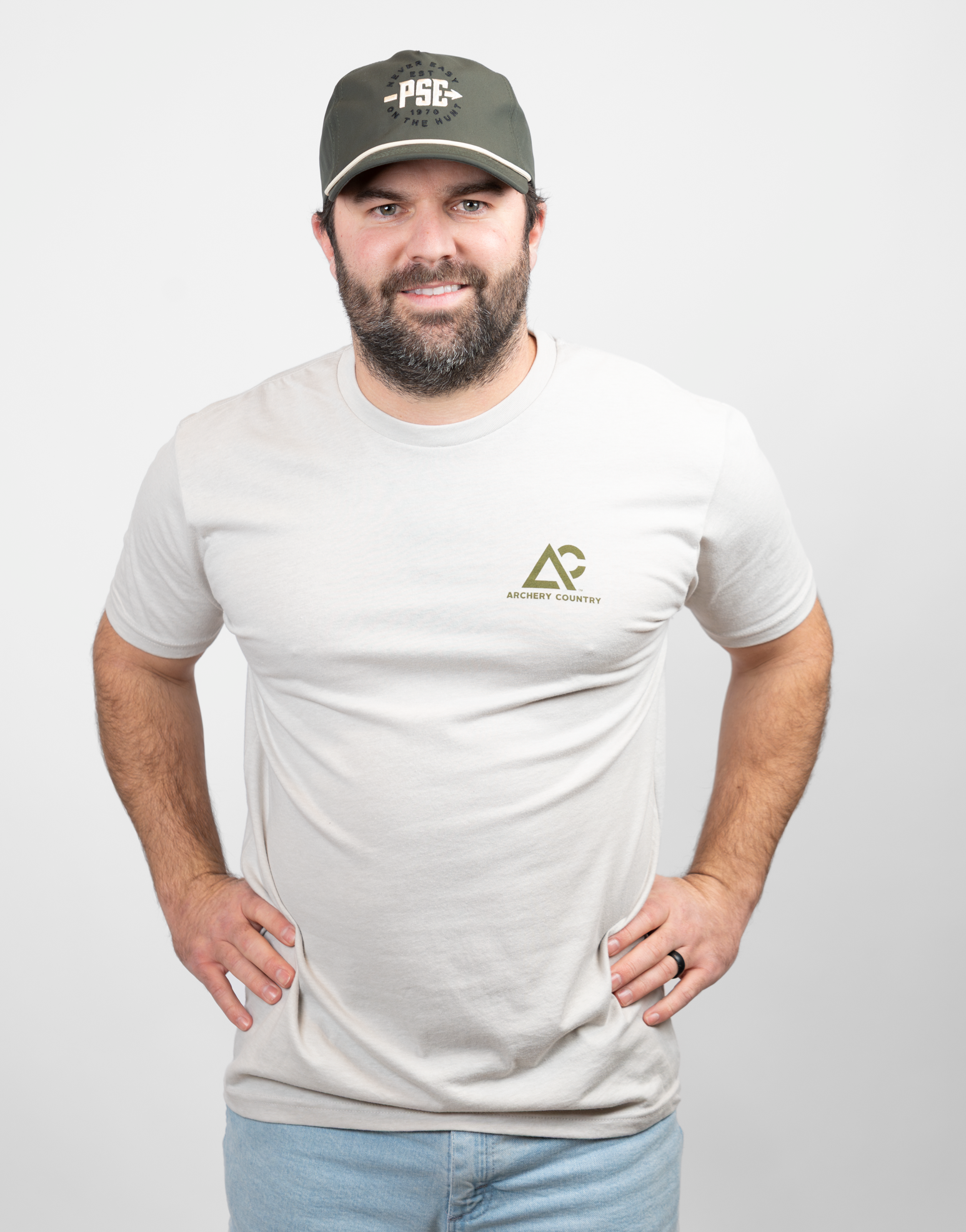 Man wearing heather sand tee with small Archery Country logo on left chest