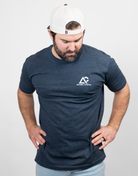 Man wearing heather navy tee with small Archery Country logo on left chest