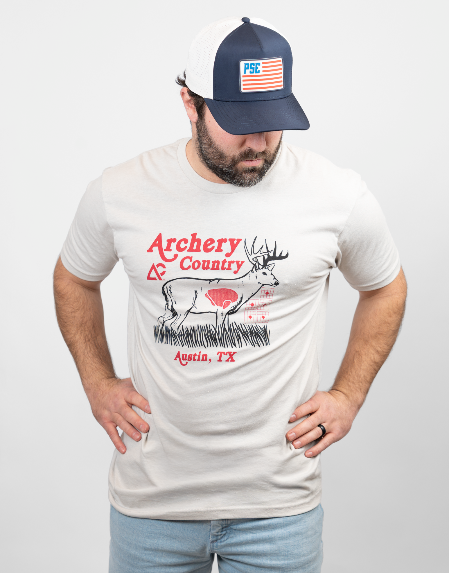 Man wearing sand tee with "ARCHERY COUNTRY Austin, TX" text and graphic of a deer