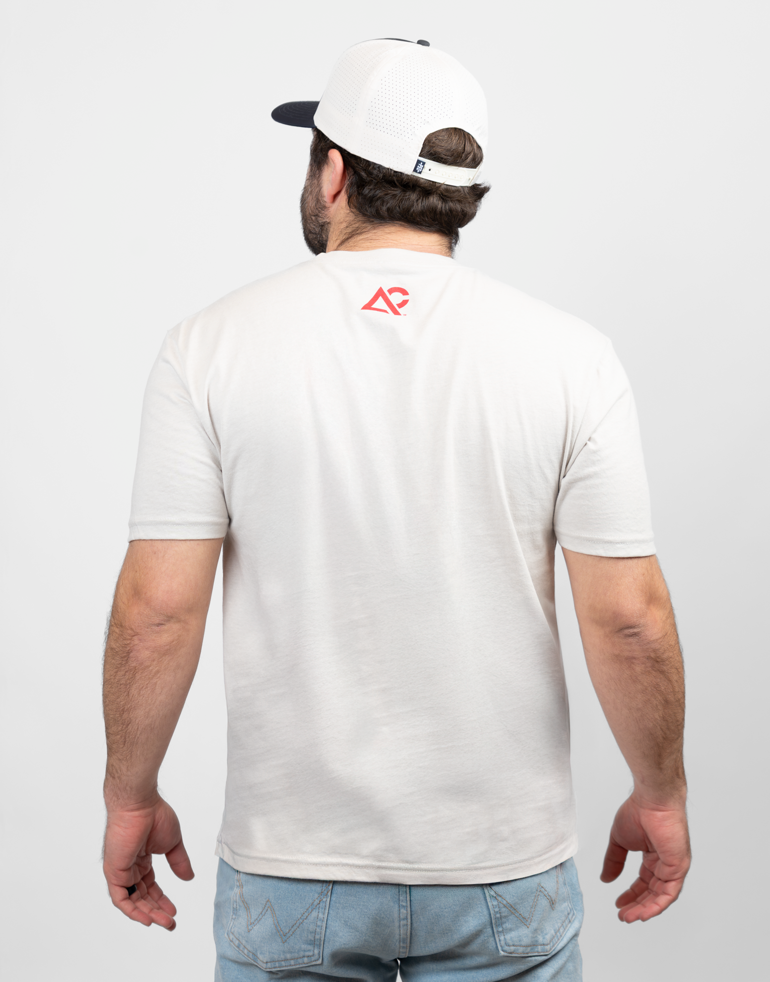 rear view of mand wearing sand tee with red Archery Country logo on upper back