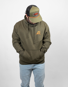 Man wearing a green hoodie with an orange Archery country logo on left chest