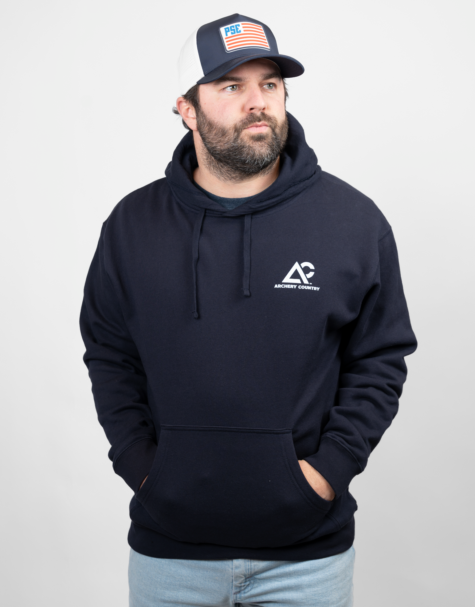 Man wearing navy hoodie with white Archery Country logo on left chest