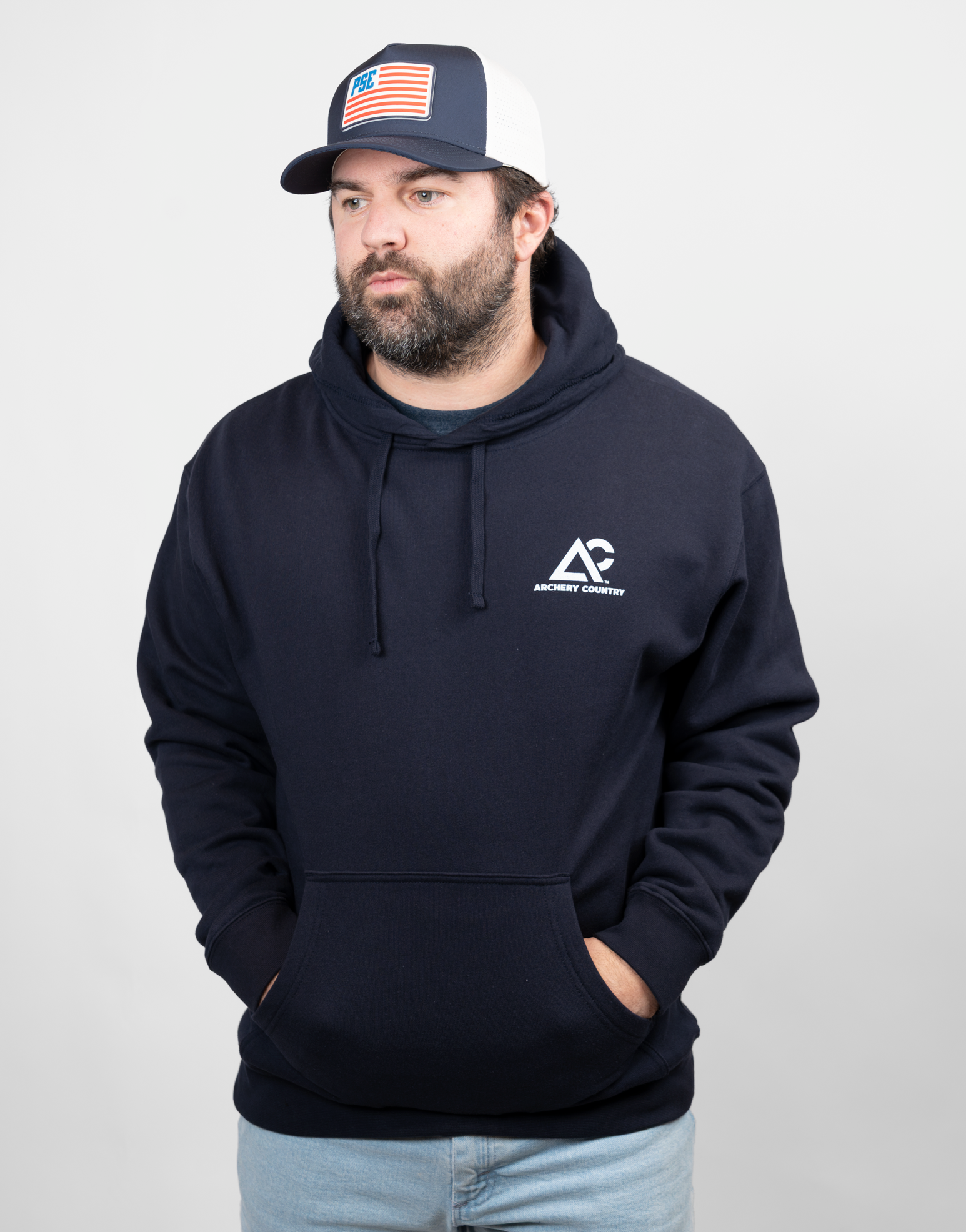 man wearing navy hoodie with white archery country logo on left chest