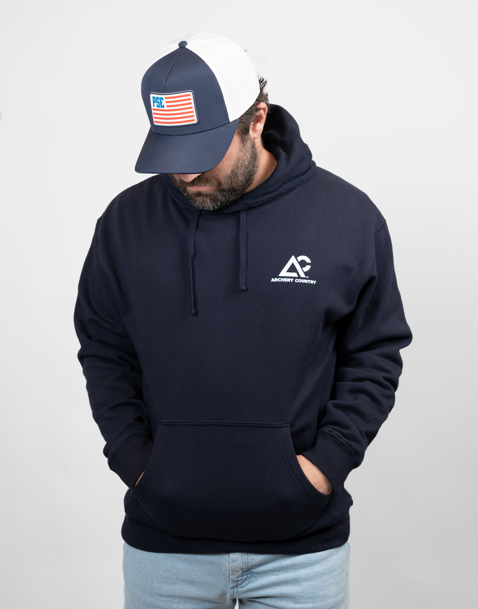 man wearing navy hoodie with white Archery Country logo on left chest