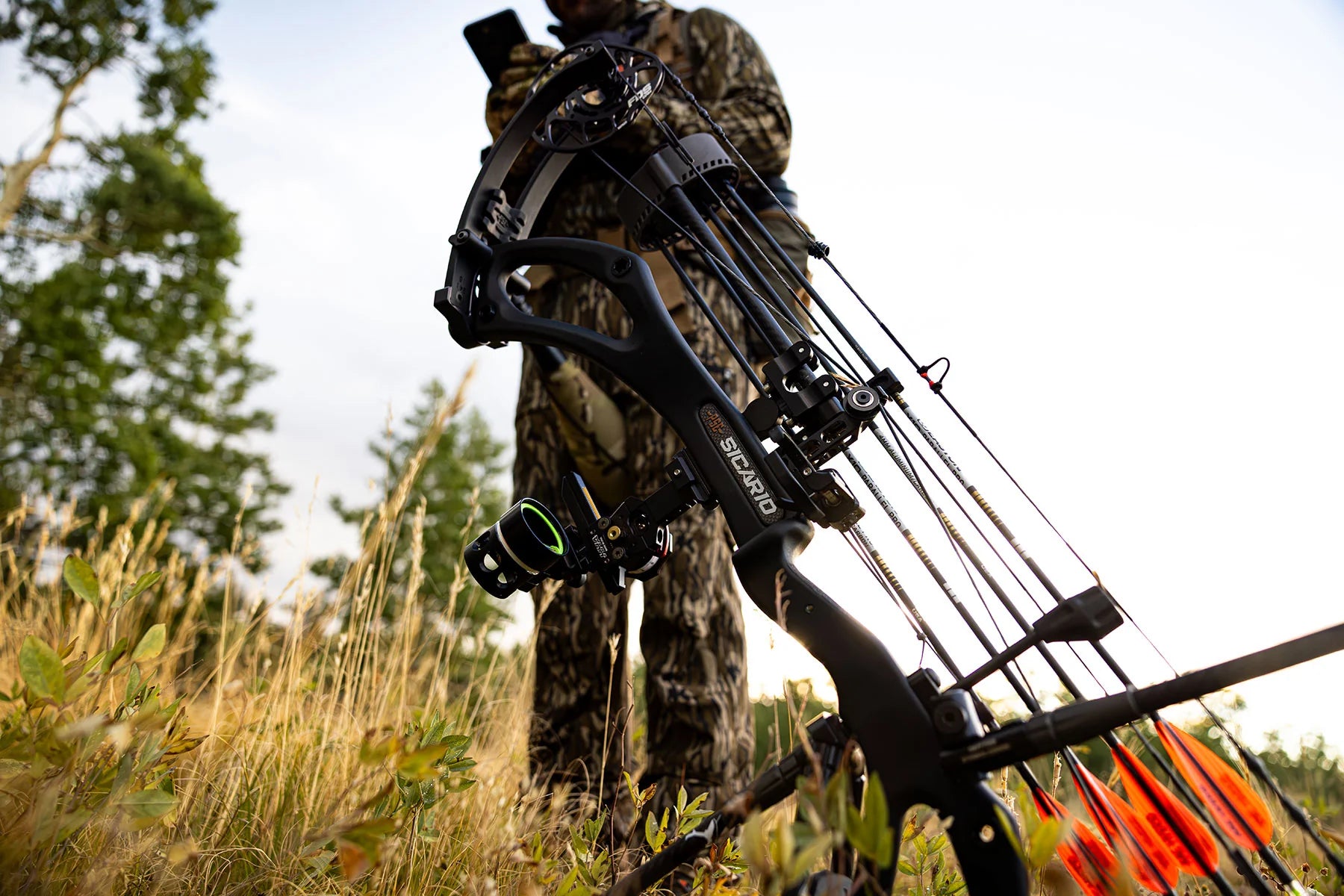 Hunting scene with a person in camouflage holding a crossbow in a natural setting.