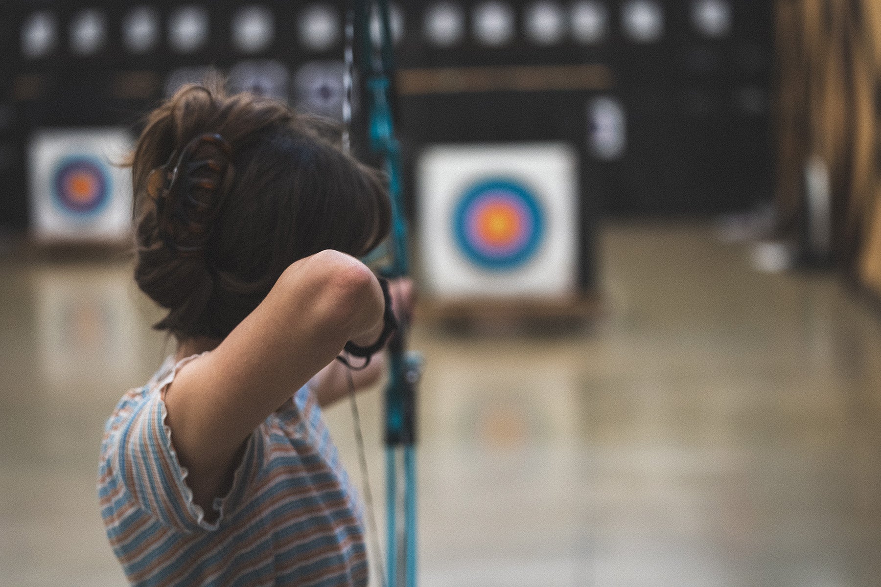 Person practicing archery with targets in the background